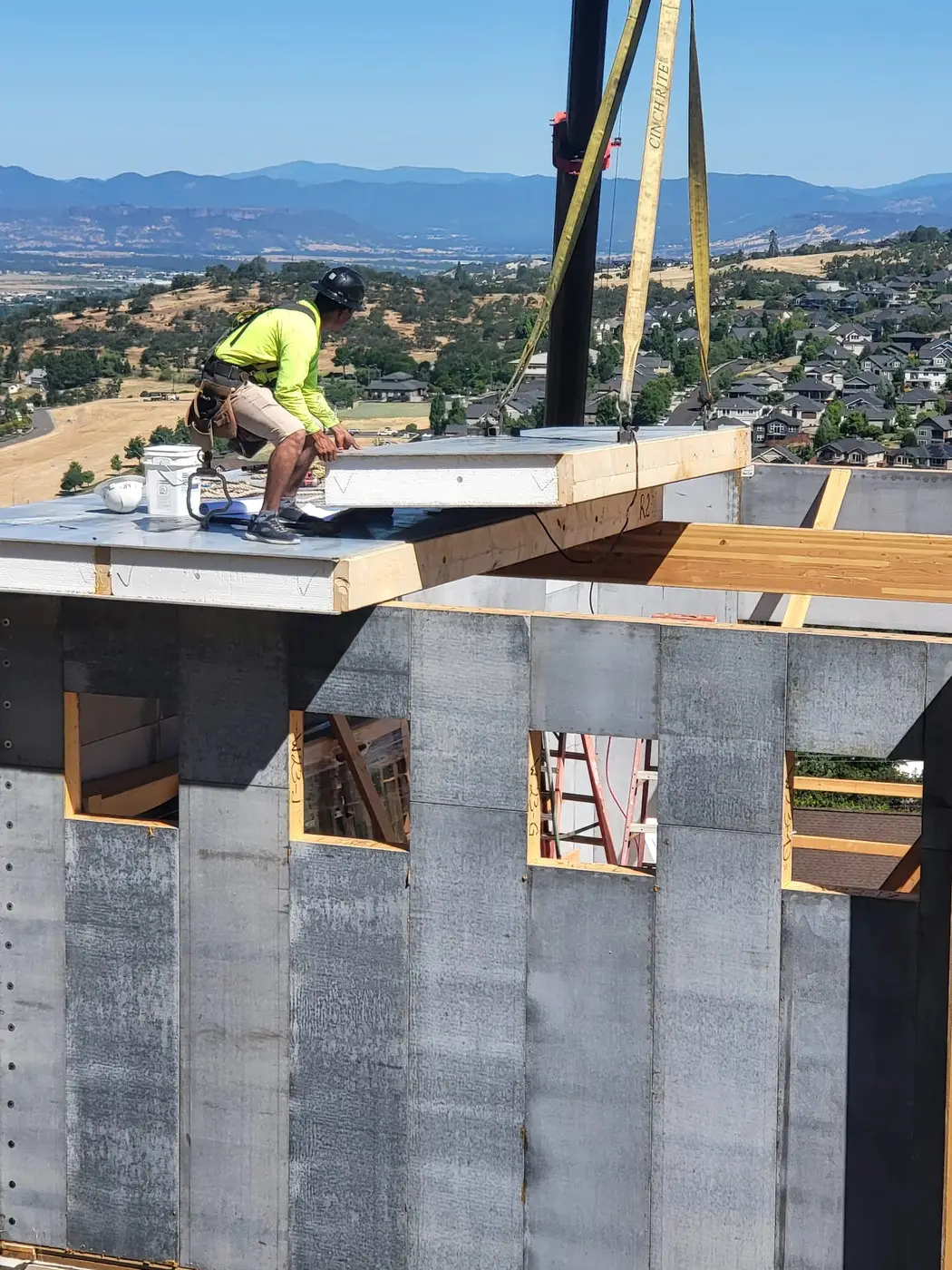 A crew setting fire-resilient modular wall panels in Medford